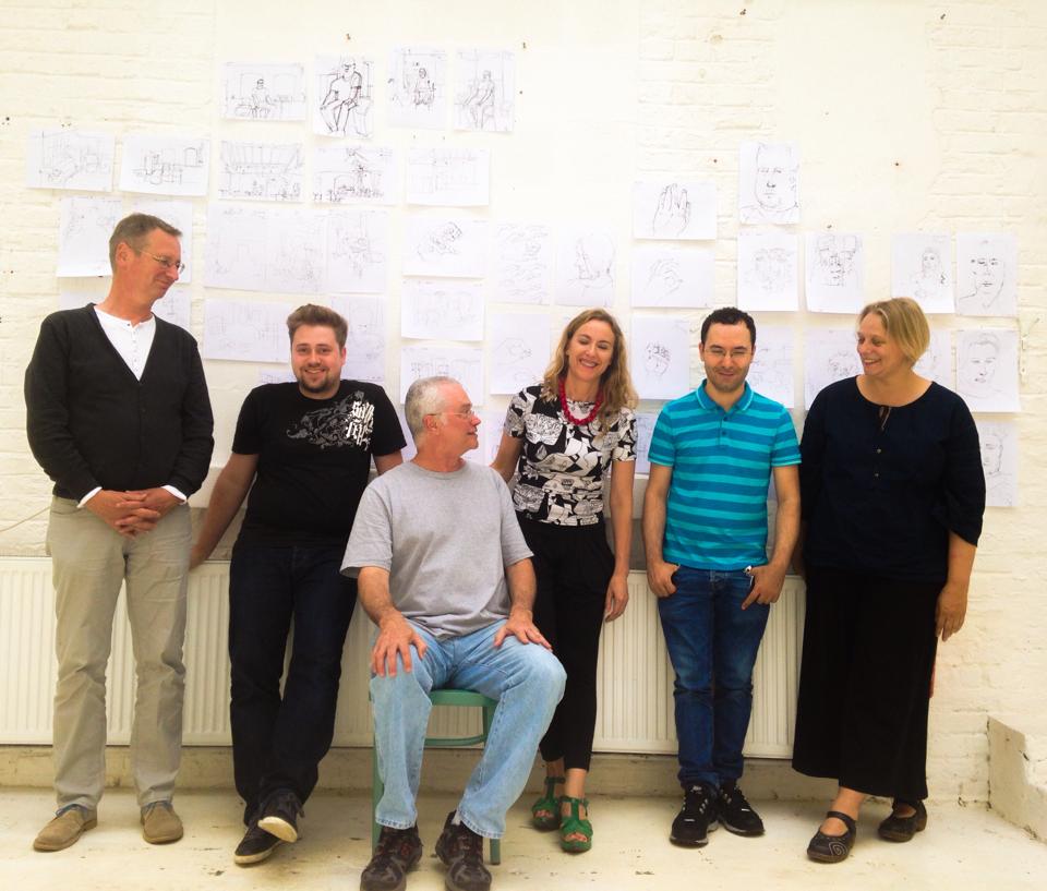 Plínio with his adult students in Frankfurt, their drawings on the wall behind them